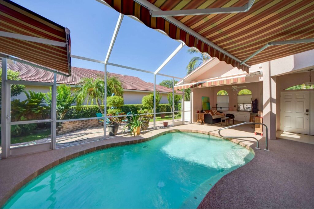 A relaxing enclosed pool area with a red and yellow striped retractable awning in sunny Orlando, Florida. Read how you can easily choose colors to match your home.