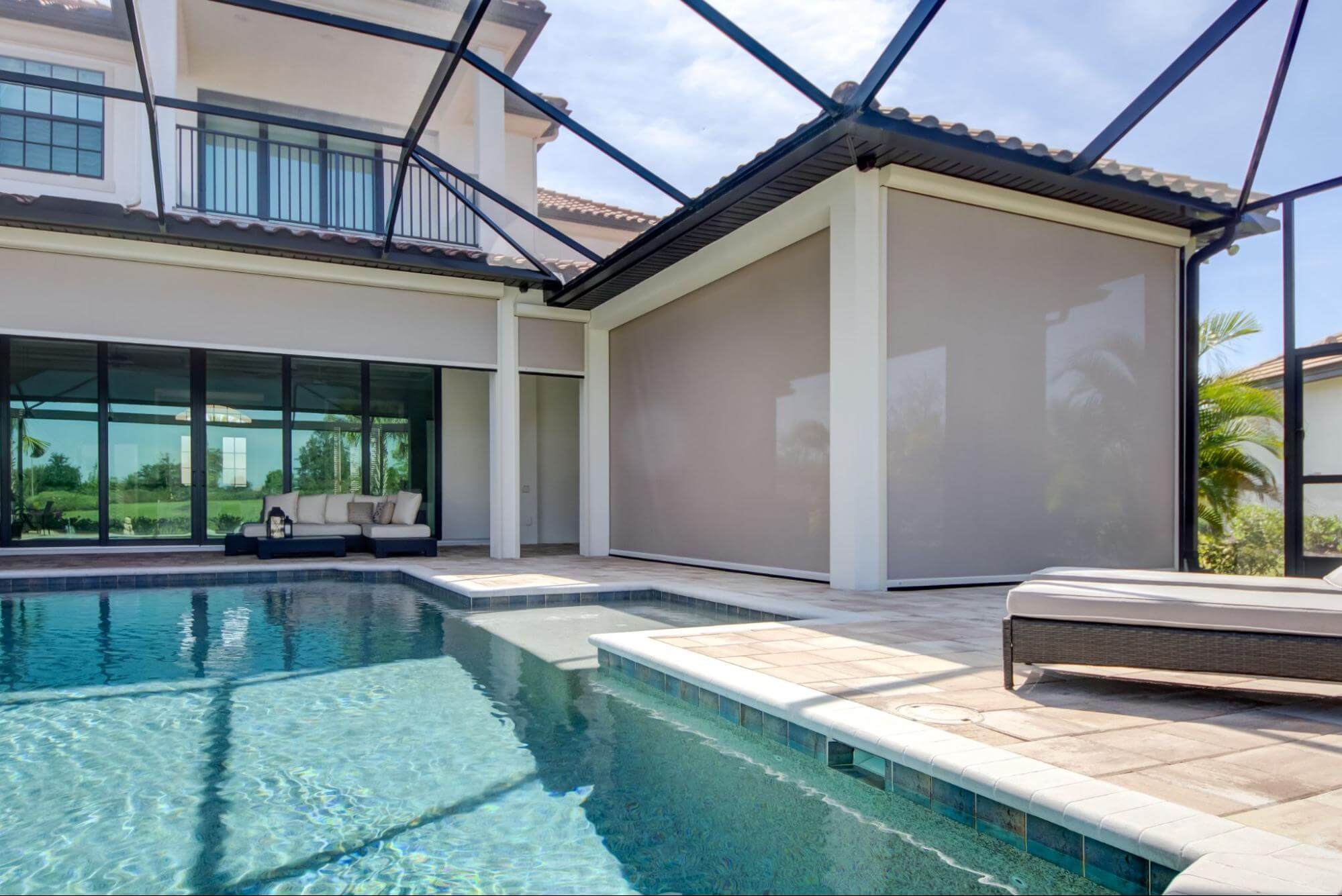 A poolside lanai features motorized privacy screens to keep out the hot sun, give them privacy, and block annoying sun glare.