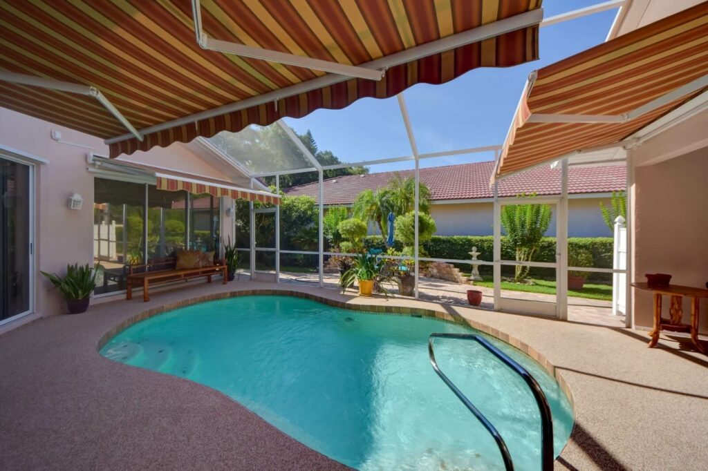 A retractable awning offers shade over a small pool.