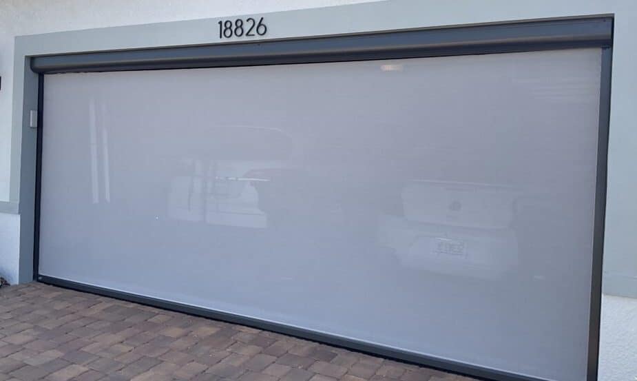 This beautiful white motorized retractable garage screen brightens this Florida home. Read this article on how to operate a retracting screen.  | Sun Protection