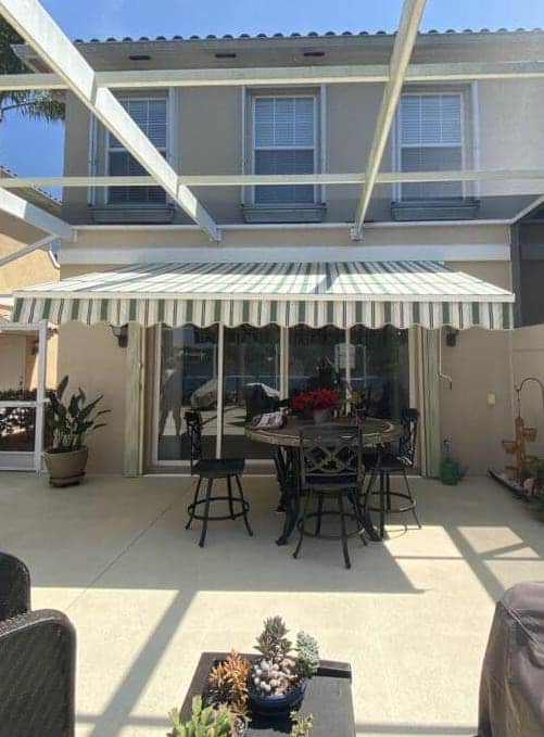 A beautiful green and white awning add color and sophistication to this Florida patio. Learn how to add style and functionality to your outdoor area. | Sun Protection