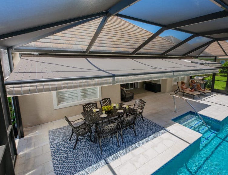 View from up top shows how this retractable motorized awning is installed over this Florida home. Homeowners have shade for dining and swimming.| Sun Protection