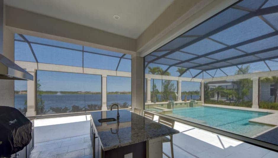 A beautiful water-front home features a pool and patio with retracting solar screens to keep the lanai cool during the hot days of summer. | Sun Protection