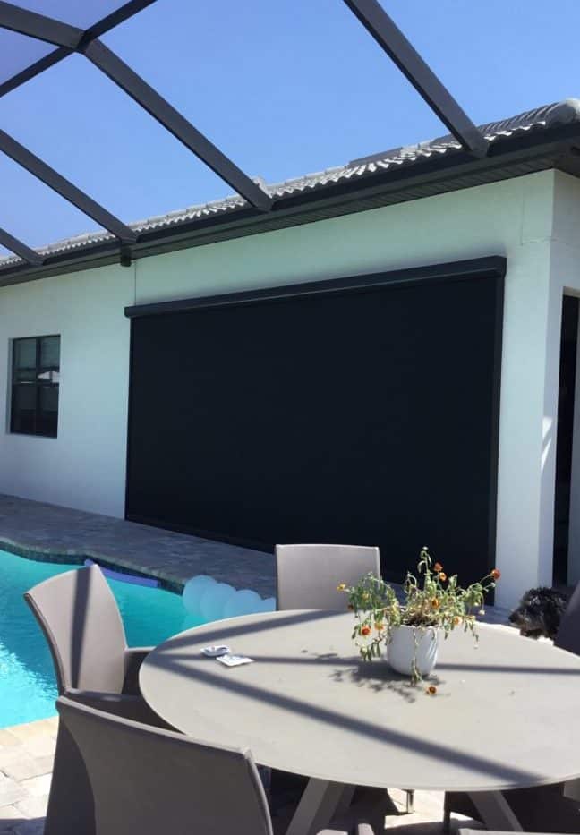 A beautiful poolside patio has protection from the hot sun, bugs, and light rain with this motorized retractable privacy screen. Instant seclusion and privacy.