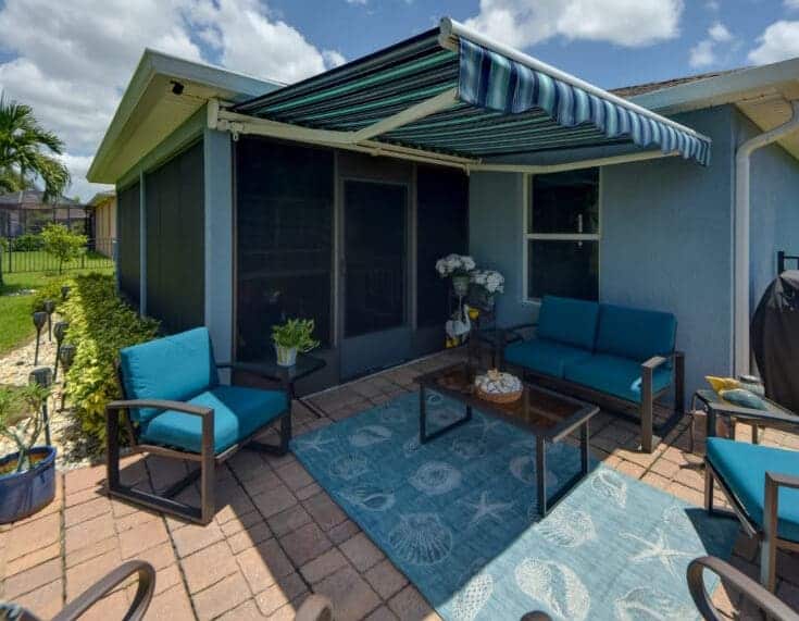 A small outdoor patio receives an instant boost in curb appeal with this bright blue retractable awning. SPF will customize your order for the size and style you want.