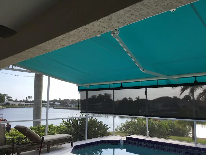 A teal retractable awning extends over a small pool with a sun shade offering additional shade.